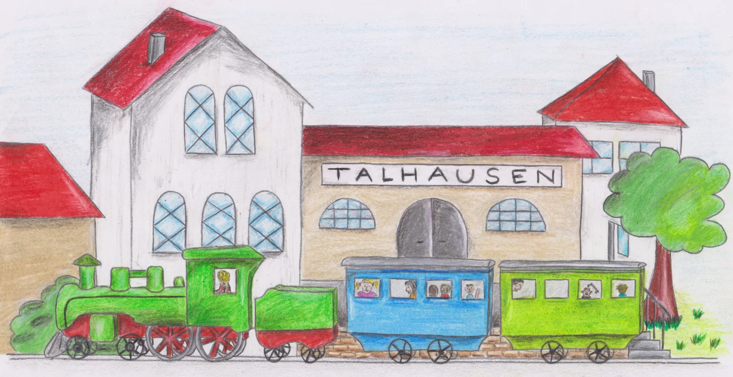 Ein grüner Zug steht vor dem Bahnhof Talhausen